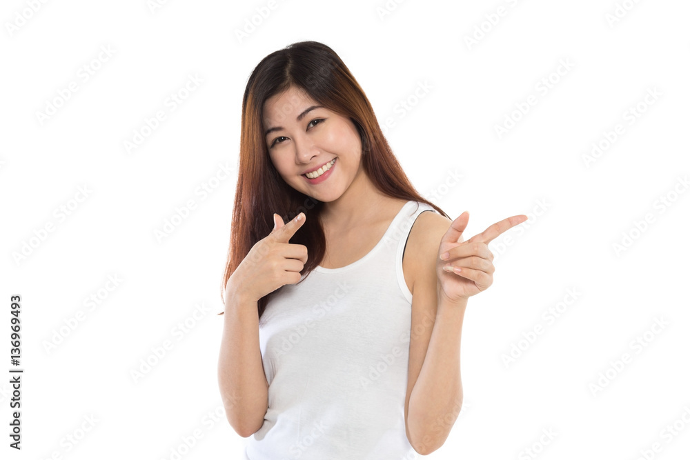 Young cute asian woman smiling and making pointing gesture isolated on white background Young cute asian woman smiling and making pointing gesture isolated on white background