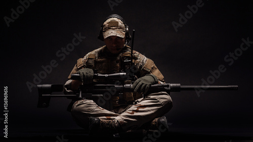 Photo Portrait soldier or private military contractor holding sniper rifle