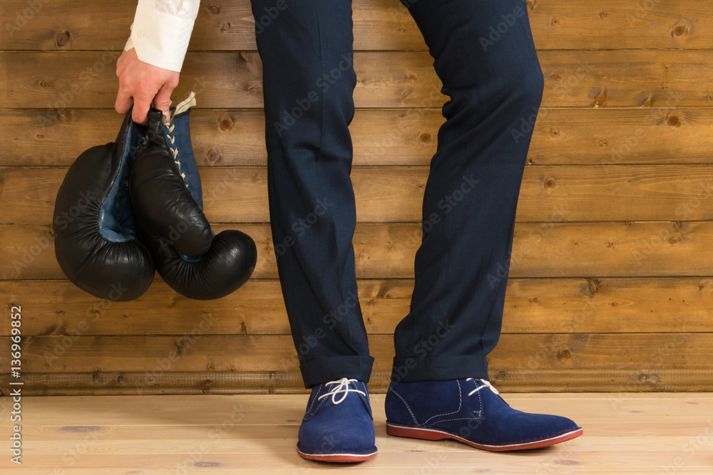 man hands holding a pair of boxing gloves on the background wall man hands holding a pair of boxing gloves on the background wall