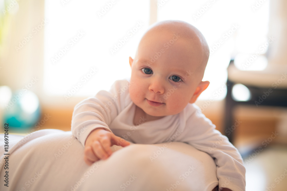 Cute baby son lying on his unrecognizable mother smiling Cute baby son lying on his unrecognizable mother smiling
