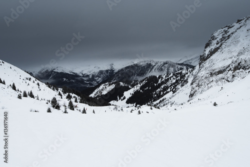 Panoramic view down a mountain valley with overcast sky