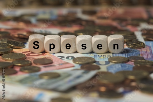 spesen - Holzwürfel mit Buchstaben im Hintergrund mit Geld, Geldscheine
