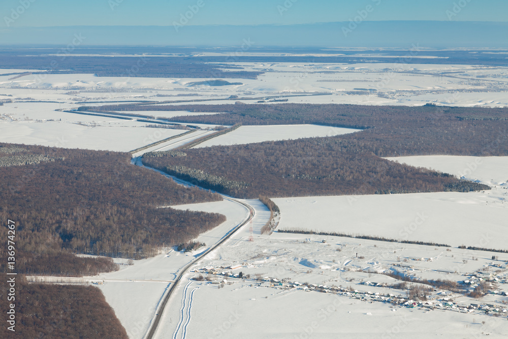 aerial view over snowy field and road