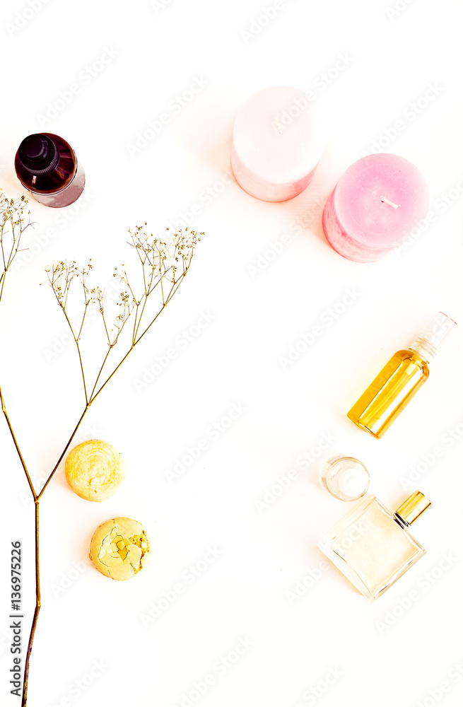 Natural cosmetics, organic oils for face, hair and body, macaroons, pink candles, flowers. Flat lay for beauty blog on a white. Copy space