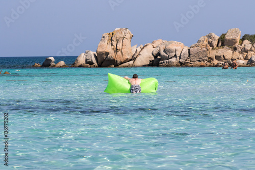 Man on airbed, view from the back in a sunny day - Sardinia, Orosei gulf; Brandinchi beach