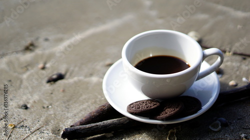 Espresso coffee and chocolate cookies. A cup of latte, cappuccino or espresso coffee on the beach.