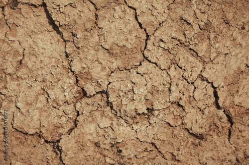 the texture of the clay , the cracks on the surface of the earth , the background is yellow
