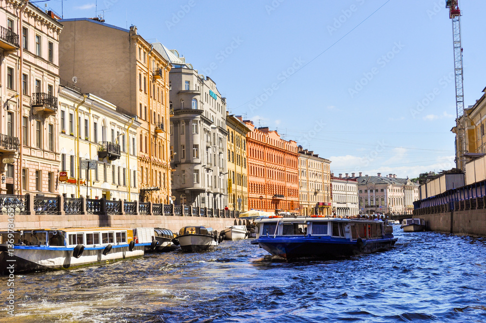 Touristic boat floats on The Moyka River is a small river in Russia that encircles the central portion of Saint Petersburg, effectively making it an island.