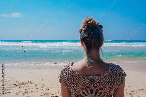 Beautiful surfer girl is enjoying vacation on the tropical beach. Young woman with surfboard in Sri Lanka.