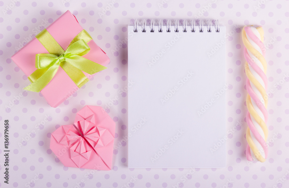 Open notebook with a blank page, Valentine origami and marshmallow stick on a background of polka dots. Copy space