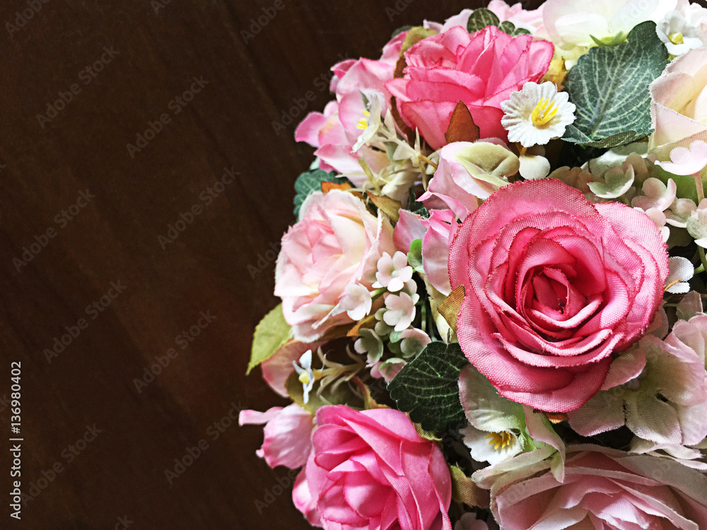 Bouquet of pink roses fake on a wooden table Bouquet of pink roses fake on a wooden table