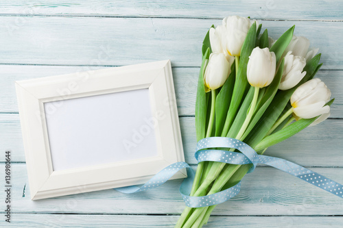 Fototapeta Naklejka Na Ścianę i Meble -  White tulips bouquet and blank photo frame