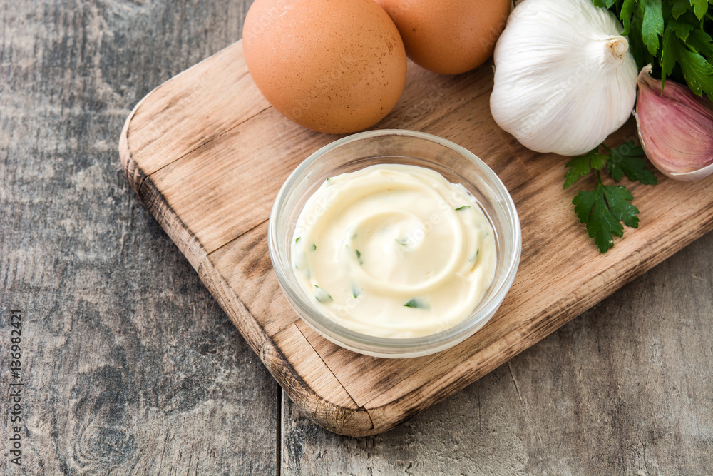 Aioli sauce and ingredients on wooden background
Aioli sauce and ingredients on wooden background