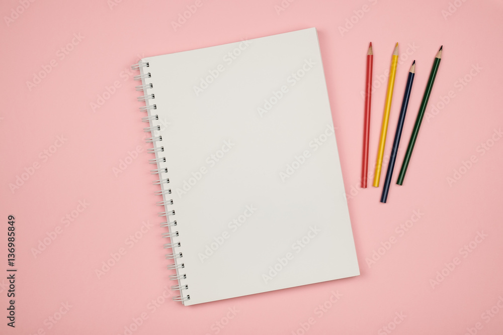 Top view of blank notebook page with colored pencils Top view of blank notebook page with colored pencils