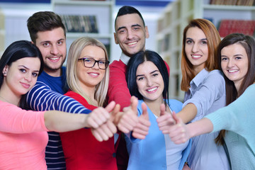 Cheerful group of students smiling at camera with thumbs up, success and learning concept