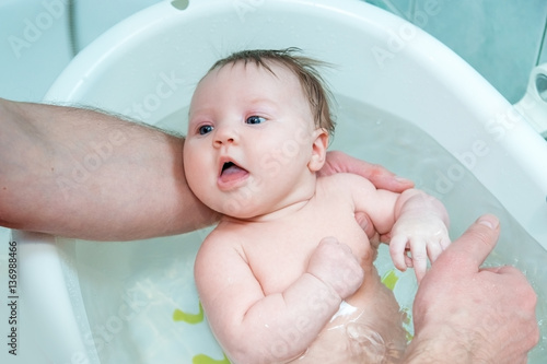 Bathing baby in a baby bath.