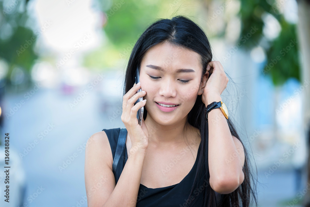 woman hand on mobile phone and wearing dress black walking on st