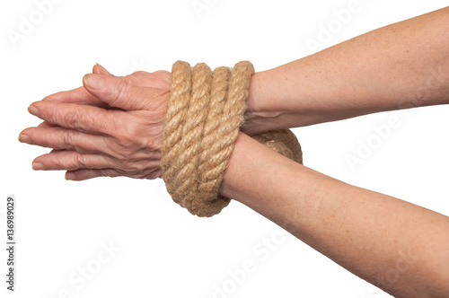 Hands of an old woman bound with rope. Isolated on white.