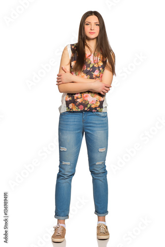 Attractive young relaxed woman, full height, with crossed arms photo