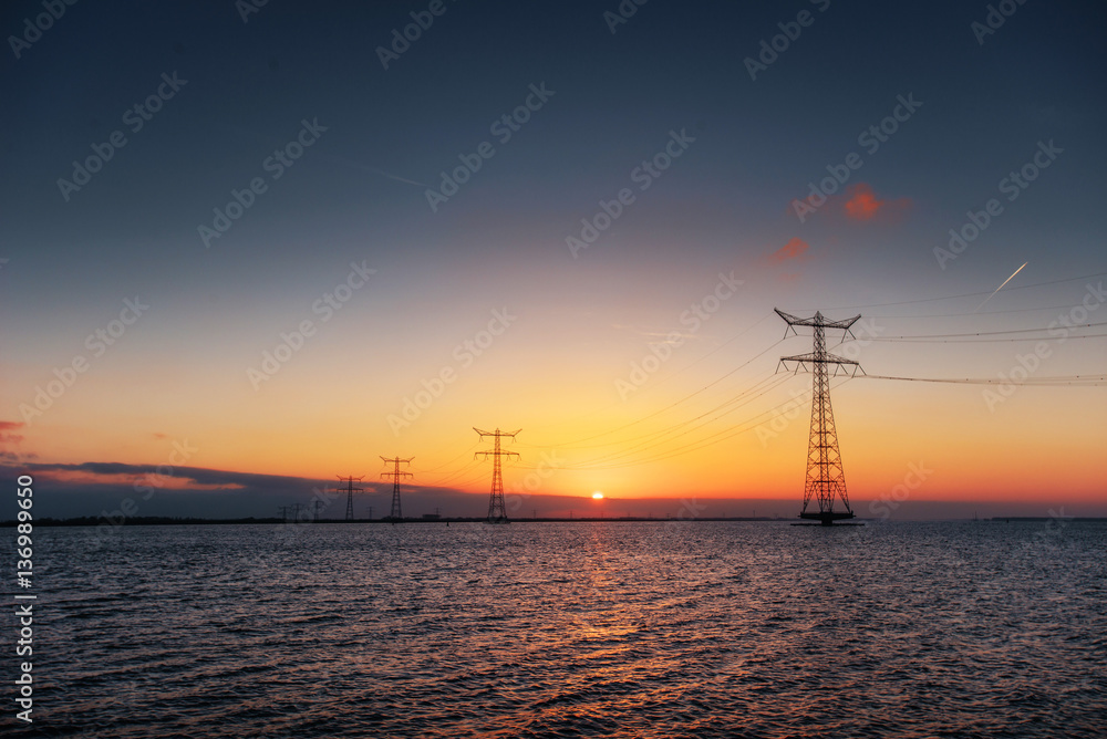 electric line above water during a fantastic sunset.