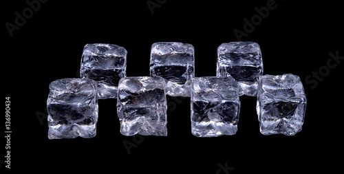 ice cubes in a two row on table on black background