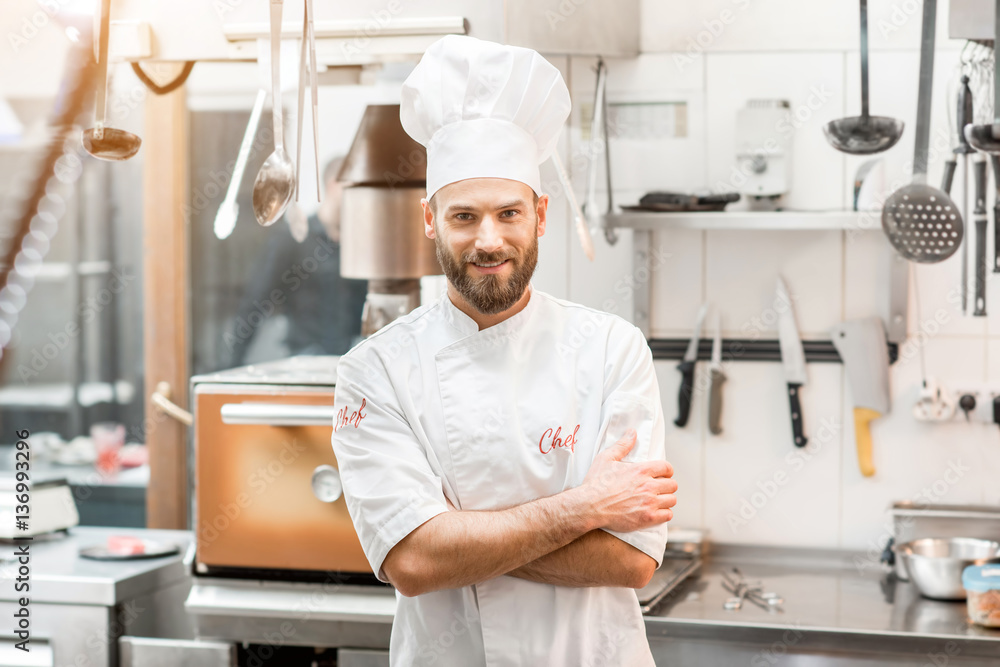 Portrait of chef cook in uniform at the restaurant kitchen