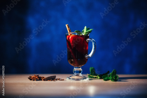 Photos Mulled wine with slice of orange and spices. Shallow dof