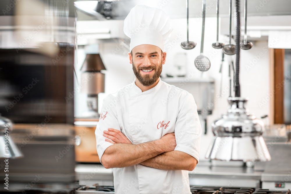 Portrait of handsome positive chef cook at the restaurant kitchen - obrazy, fototapety, plakaty 