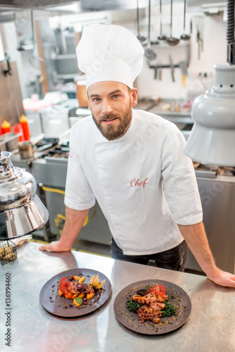 Portrait of chef cook in uniform with prepaired delicious dish at the restaurant kitchen photo