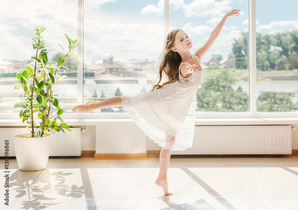 Cute little ballerina in white ballet costume is dancing Cute little ballerina in white ballet costume is dancing