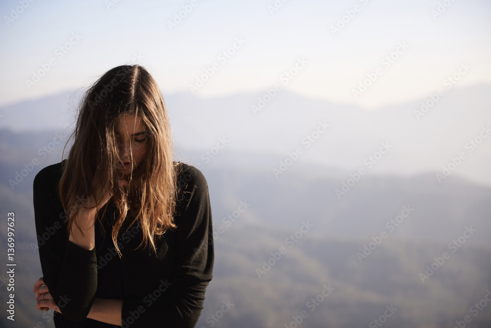 Woman with eyes closed standing against mountains Woman with eyes closed standing against mountains