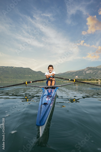 Fototapeta The young sportsman is rowing on the racing kayak