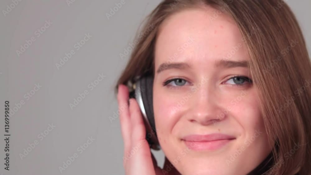 attractive girl with headphones on gray background. attractive girl with headphones on gray background.