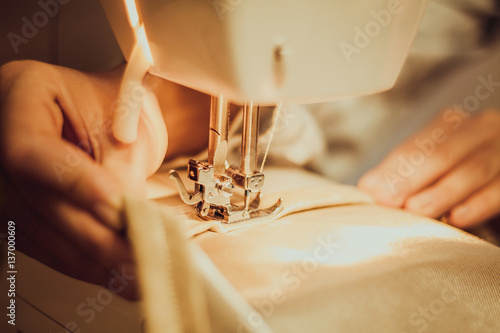 close-up hands of a seamstress at the sewing machine, toning 