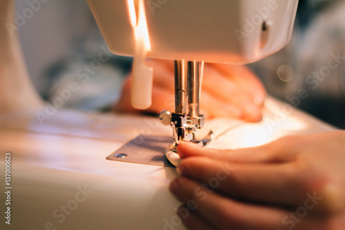 Fototapeta Naklejka Na Ścianę i Meble -  close-up hands of a seamstress at the sewing machine