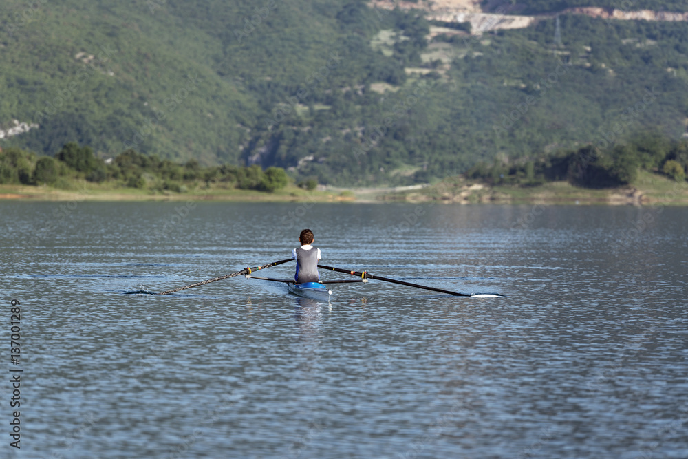 Child in the course of rowing on single Child in the course of rowing on single
