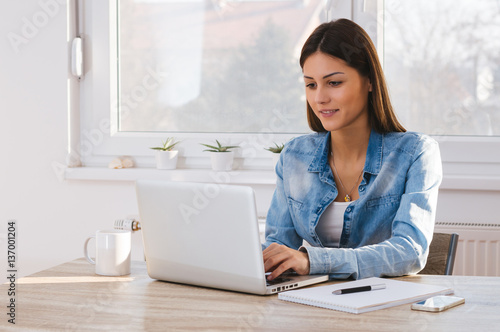 Portrait of happy young woman using laptop