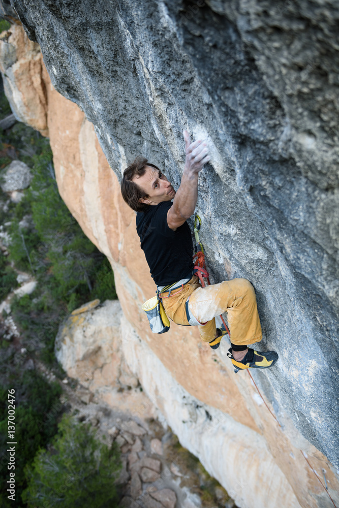 Rock climber ascending a challenging cliff. Extreme sport climbing. Freedom, risk, challenge, success. Rock climber ascending a challenging cliff. Extreme sport climbing. Freedom, risk, challenge, success.