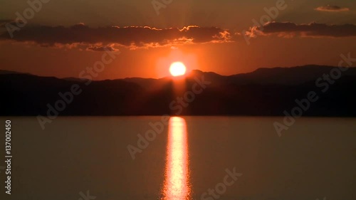 Sunset behind hills and lake timelapse