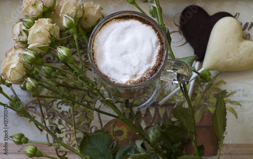 cappuccino with chocolate hearts and rose on a tray