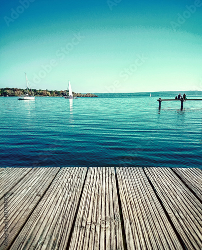 Fotografie Couple dreaming on water jetty by lake
