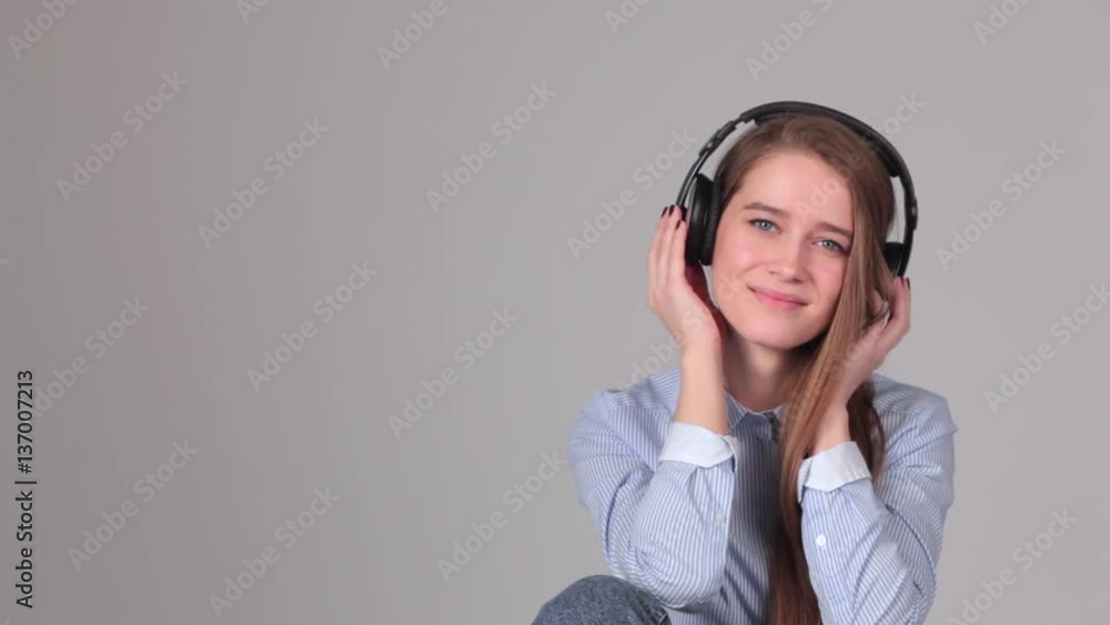 attractive girl with headphones on gray background. attractive girl with headphones on gray background.