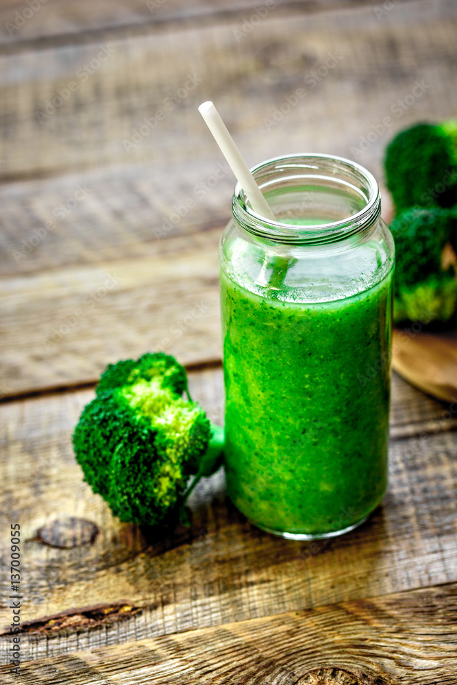 Green vegetable smoothie in glass at wooden background Green vegetable smoothie in glass at wooden background