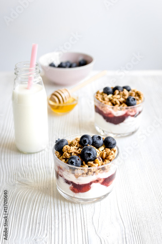Cooking breakfast with granola and berries on white kitchen background