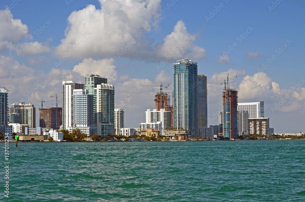 Miami skyline with luxury condominiums and luxury condominiums under construction overlooking biscayne bay.