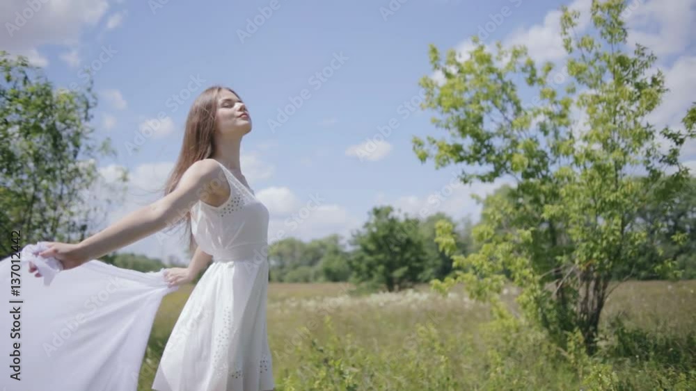 Young pretty woman holding white cloth on wind. Medium shot Young pretty woman holding white cloth on wind. Medium shot