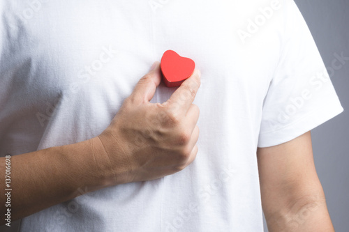 A man hand with wooden red heart object