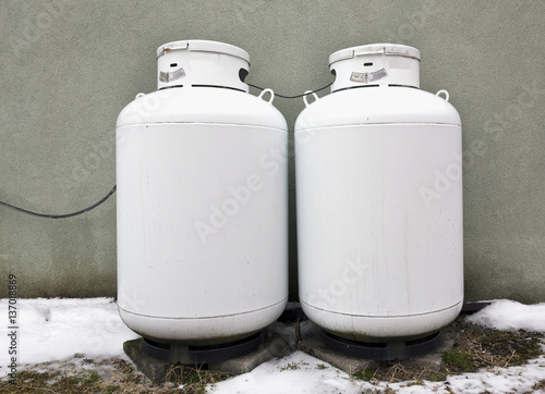 Two home propane tanks against wall. with snow on the ground  photo