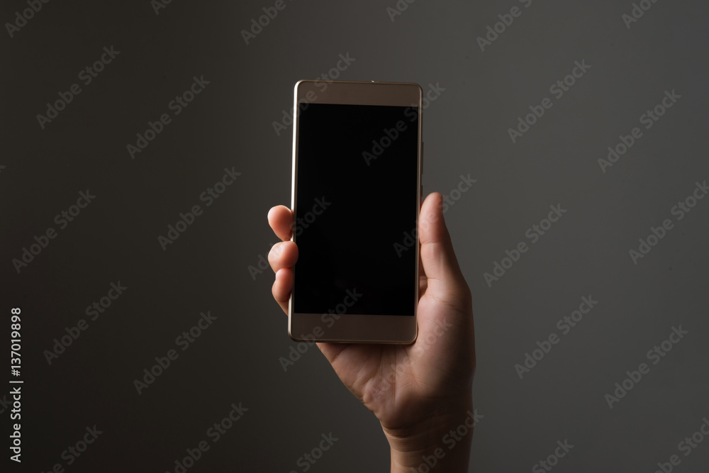 Φωτογραφία Woman hand with smartphone isolated on black.