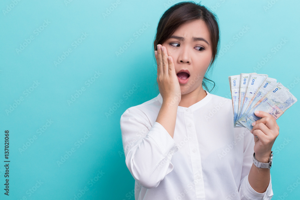 Surprised asian woman holding a lot of banknote fifty baht Surprised asian woman holding a lot of banknote fifty baht